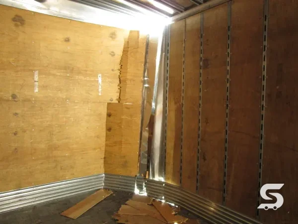 Interior de la caja seca con el forro de madera desprendido y el panel deformado, antes de la reparación — Talleres Saucedo, Uruapan, Michoacán
