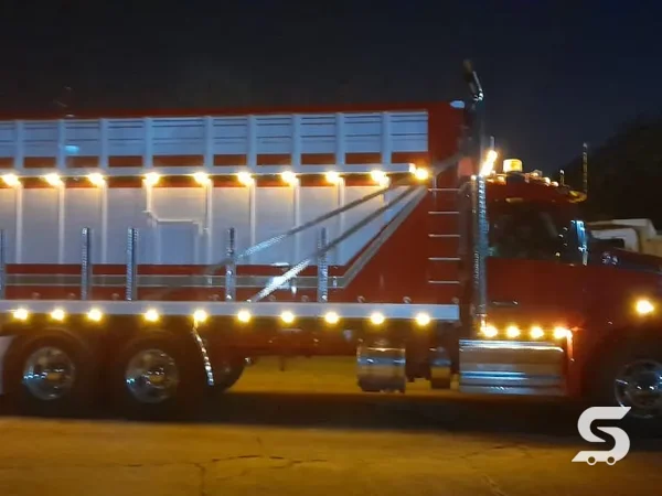 Carrocería tipo jaula terminada sobre tortón Kenworth, con luces de gálibo encendidas de noche — Talleres Saucedo, Uruapan, Michoacán