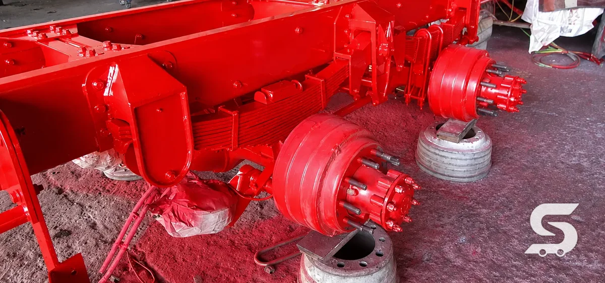 Suspensión mecánica de muelles con perchas reticuladas montada en chasis, terminada y pintada en rojo — Talleres Saucedo, Uruapan, Michoacán